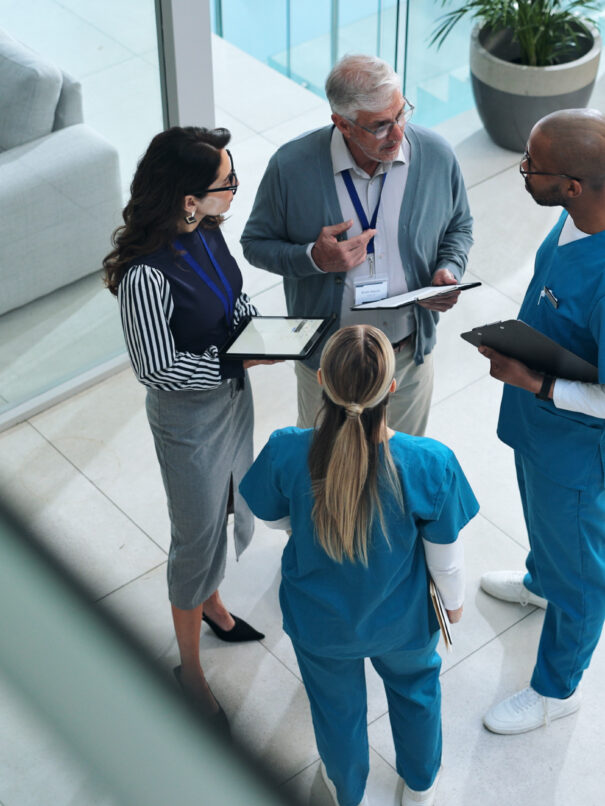 Group of health payers and medical providers talking in a hospital lobby